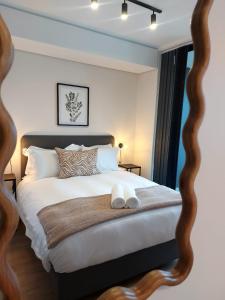 a bedroom with a large bed with a wooden frame at 308 The Meadows Luxury Deluxe in George