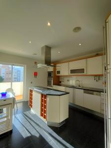 a kitchen with white cabinets and a black counter top at Welkome Inn Bemposta Confort T2 in Alvor