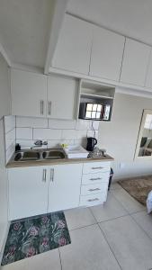 a kitchen with white cabinets and a sink at Protea Rus in Wellington +22 photos