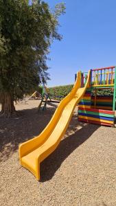 a yellow slide in a park with a playground at oasis de paix in Aït Amara