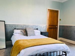 キャッスル・ドニントンにあるCastle Donington 5 Bed House 2 Baths Near EMA And Donington Parkのベッドルーム1室(大型ベッド1台、金の毛布付)