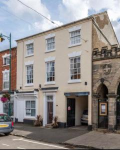 キャッスル・ドニントンにあるCastle Donington 5 Bed House 2 Baths Near EMA And Donington Parkの通りに面した建物とその前に駐車された車