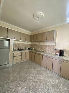 a kitchen with brown cabinets and stainless steel appliances at Dar el baraka in Ras El Ma