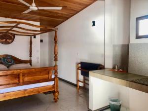 ein Schlafzimmer mit einem Bett mit Deckenventilator in der Unterkunft Erly Place - Guest House and Restaurant in Hikkaduwa