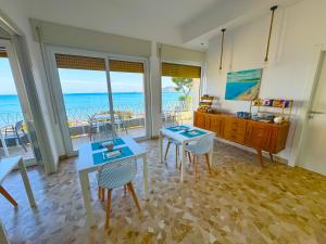 a living room with tables and chairs and the ocean at Villa Magnolia in Formia