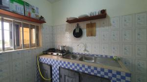 a kitchen with a sink and a stove at Appartement meublé à Fidjrossè Cotonou in Cotonou +3 photos