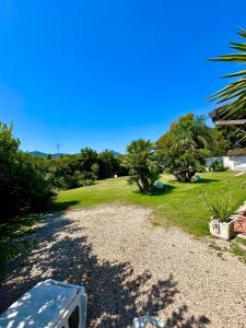 a gravel driveway with trees and a grass field at Dependance in Villa in San Felice Circeo