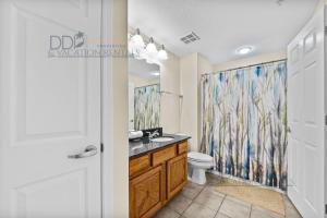 a bathroom with a toilet and a shower curtain at Legacy Tower II 403 in Gulfport