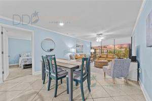 Un comedor y una sala de estar con mesa y sillas. en Ocean Club Villa B-319, en Biloxi