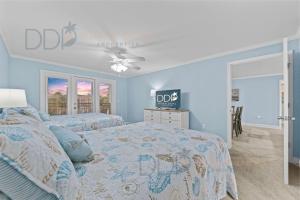 Un dormitorio con dos camas y un ventilador de techo. en Ocean Club Villa B-319, en Biloxi