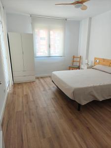 ein Schlafzimmer mit einem Bett und einem Holzboden in der Unterkunft Esencia Mediterránea in Vinarós
