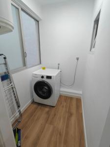 eine Waschmaschine in einer Waschküche mit Fenster in der Unterkunft Esencia Mediterránea in Vinarós