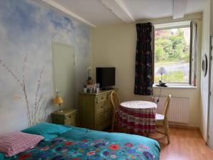 a bedroom with a bed and a table and a window at Au fil de Lods in Lods
