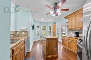 a kitchen with wooden cabinets and a ceiling fan at Legacy Villa 1501 in Gulfport