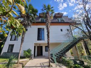 a house with palm trees in front of it at Villa Gelati in Kutaisi