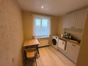a small kitchen with a table and a window at Satiksmes apartment in Jelgava