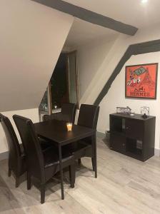 a dining room with a black table and chairs at Appartement refait à neuf en centre ville in Bonneuil-sur-Marne