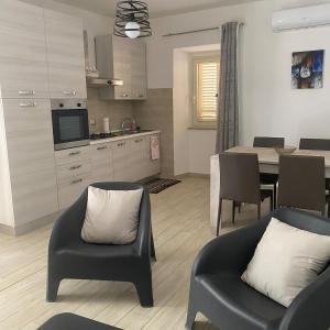 a kitchen and living room with a table and chairs at La Dolce Sosta in Luras