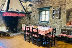 a table and chairs in a room with a stone wall at Goikitxe Etxea in Goizueta