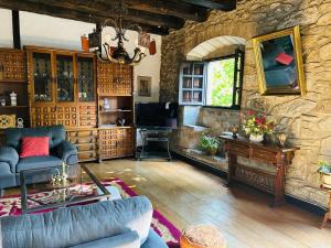 a living room with a couch and a stone wall at Goikitxe Etxea in Goizueta