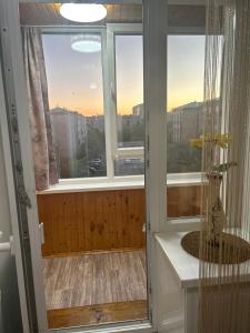 a room with windows and a view of a city at УЮТ 2-комнатная квартира в центре in Petropavlovsk