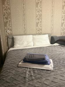 a bed with a towel on top of it at УЮТ 2-комнатная квартира в центре in Petropavlovsk