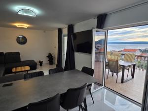 a living room with a table and chairs and a balcony at Mateo in Novi Vinodolski
