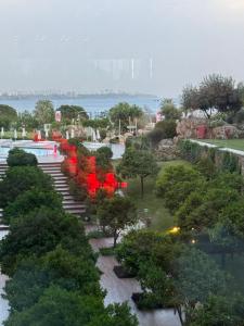 a park with red chairs and trees and the water at Pensiunea Adriana in Tulcea