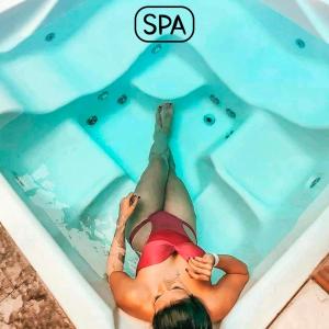 a woman laying in a swimming pool at Hotel Natural Brotas - SPA & Lazer in Brotas