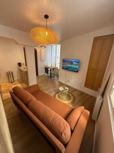 a living room with a couch and a table at Cocon Écorce & Mandarine in Joigny