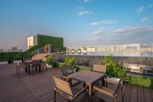 a patio with tables and chairs on a roof at Boutique Stay w Private Jacuzzi - Belmore Stays in Gurgaon