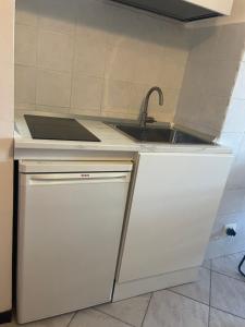 a white kitchen with a sink and a counter at Mansarda N12 Galliari in Turin