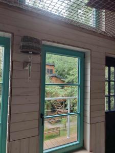 una habitación con una puerta y una ventana con vista en Węgiełek Treehouse Little Barn, en Kazimierz Dolny