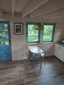 comedor con mesa y sillas y puerta azul en Węgiełek Treehouse Little Barn, en Kazimierz Dolny
