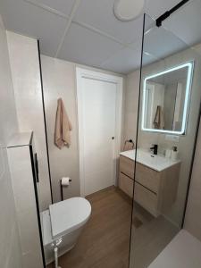 a bathroom with a toilet and a sink and a mirror at Apartamento García in Nerja