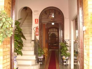 an entrance to a building with a hallway with stairs at Hostal Toscano in San Juan del Puerto