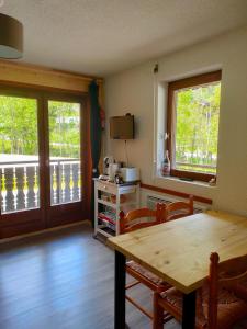a kitchen with a wooden table and chairs and a balcony at Studio Châtel Secteur Linga Proche Pistes in Châtel