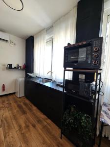 Una cocina con un microondas sobre un soporte con encimera. en Ehad Haam Urban Suite, en Haifa