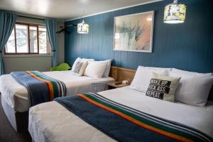 two beds in a room with blue walls at Lodge at Poncha Springs in Salida