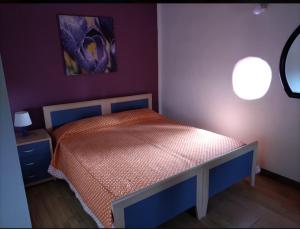 ein Schlafzimmer mit einem Bett in einem lila Zimmer in der Unterkunft Mari e Suli in Favara
