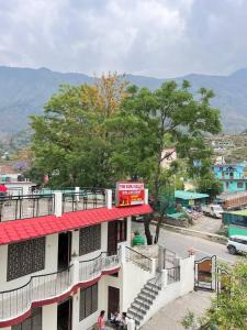 a building with a red roof on a city street at The kunj valley aasriwad in Pīpalkoti