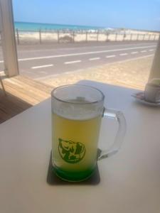 a glass of beer sitting on a table near the beach at Wohnen am Reiterhof, 50 qm, mit Gartennutzung in Hagen