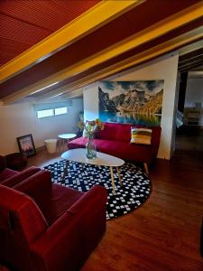 a living room with a red couch and a table at Villa Mirador del Sol, 45min playas de Doñana, 35min de Sevilla in Villalba del Alcor +51 photos