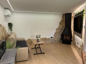 een woonkamer met een bank en een open haard bij Padul Suites Apartamentos in Padul