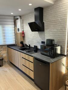 een keuken met een fornuis en een magnetron bij Padul Suites Apartamentos in Padul