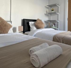 two beds with towels on them in a bedroom at Edenderry Central Rooms in Edenderry