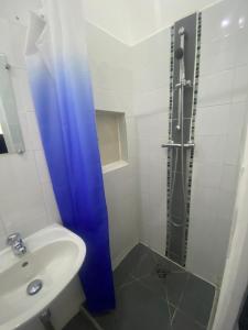 a bathroom with a blue shower curtain and a sink at LaVIVA 1er in Calais +13 photos