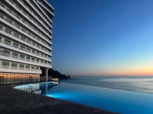 a hotel with a swimming pool next to the ocean at Babmoo Beach tsikhisdziri N169 in Ts'ikhisdziri