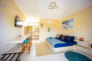 a bedroom with a blue bed and a desk at Atenea 3 private bedrooms in Holbox Island