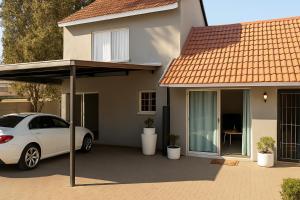 a white car parked in front of a house at 46 On Aries Studio Apartment in Northwold